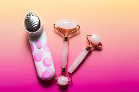 Set of various facial massagers on bright pink ombre backgroundの写真素材