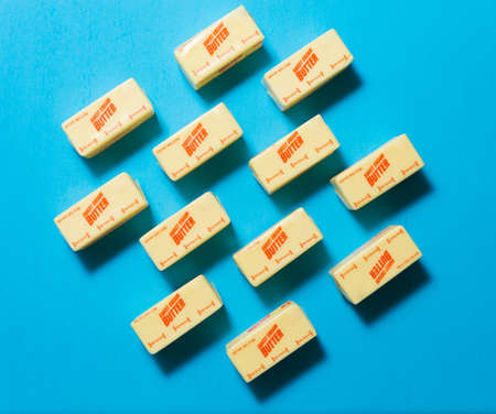 Blocks of sweet cream butter on a blue background from high angleの写真素材
