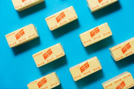 Blocks of sweet cream butter on a blue background from high angleの写真素材