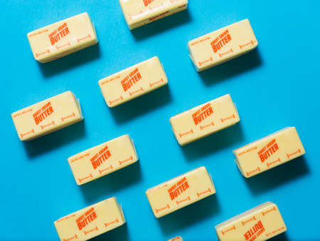 Blocks of sweet cream butter on a blue background from high angleの写真素材