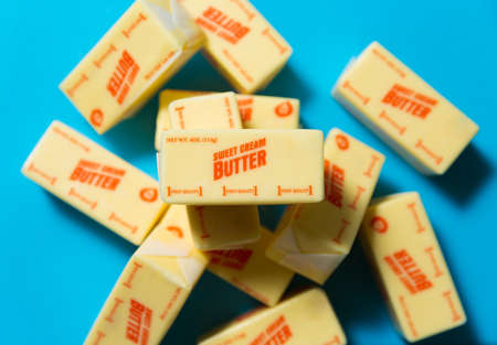 Blocks of sweet cream butter on a blue background from high angleの写真素材