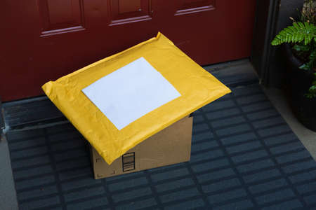A box and a mailer on a doorstep, online order home delivery conceptの写真素材