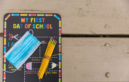 First day of school chalkboard with a face mask and school suppliesの写真素材