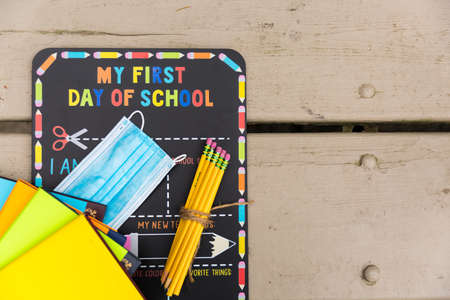 First day of school chalkboard with a face mask and school suppliesの写真素材