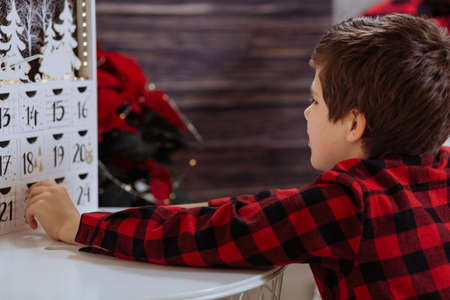 Boy counting day till Christmas with an advent calendarの写真素材