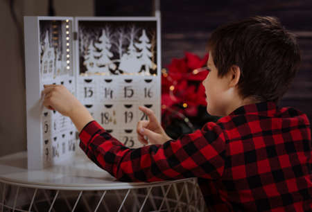 Boy counting day till Christmas with an advent calendarの写真素材