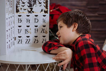 Boy counting day till Christmas with an advent calendarの写真素材