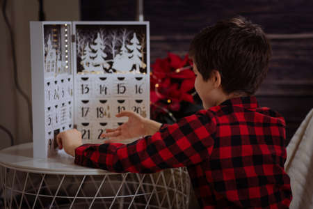 Boy counting day till Christmas with an advent calendarの写真素材