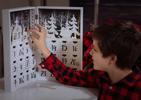 Boy counting day till Christmas with an advent calendarの写真素材