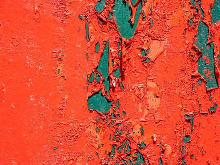 peeling off the paint on a red wall