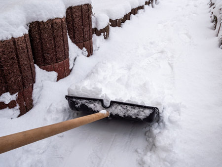 Snow shoveling on the sidewalkの写真素材