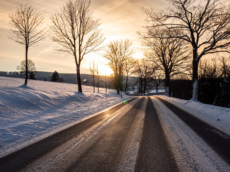 Sun dazzles road traffic in winterの写真素材