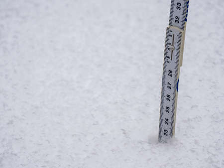 Measure the snow depth with a folding ruleの写真素材