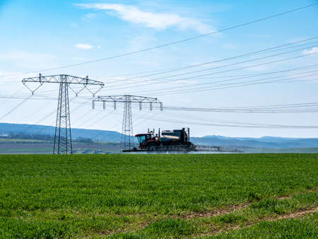 Tractor sprays pesticide on a fieldの写真素材