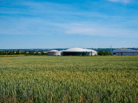 Biogas plant behind a wheat fieldの写真素材