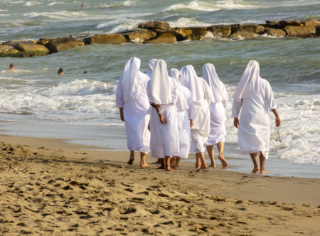 Nuns walk in the sand on the Italia beach