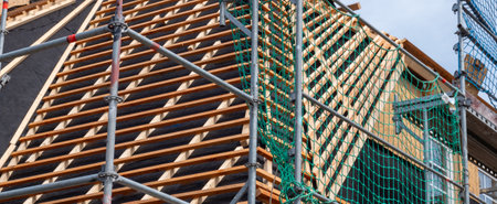 New construction of a roof with scaffolding and roof tiles