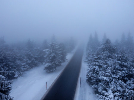 snow covered road in winter with fogの写真素材