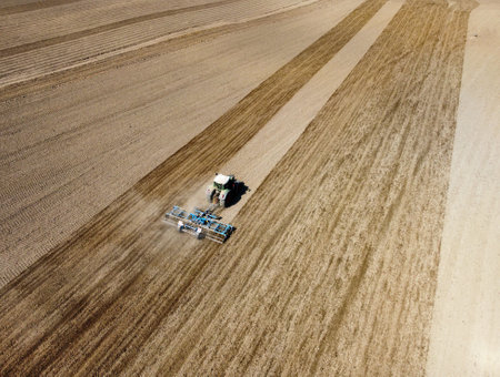 tractor plowing on the grain field in the summerの写真素材