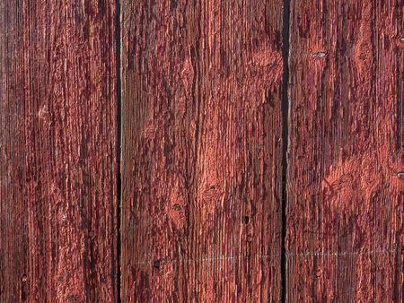 Old red wooden wall with peeling paintの写真素材