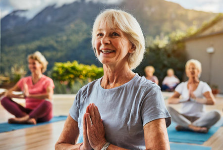Elderly woman participating in a group yoga sessionの素材