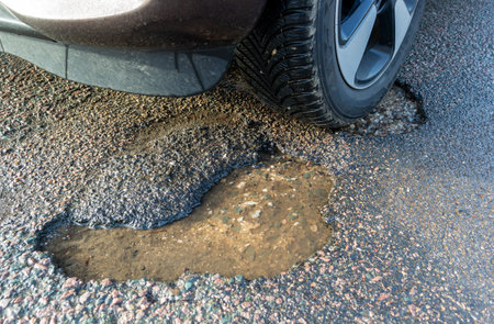 Pothole after frost on the roadの写真素材