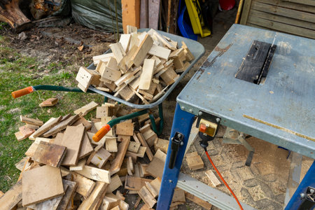Circular saw with cut firewood in the background in a wheelbarrowの写真素材