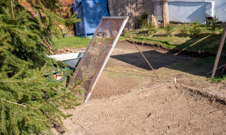 Soil is sifted through a construction site in the gardenの写真素材