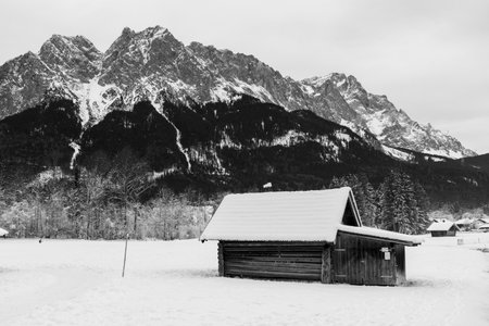 Old wooden house at the foot of the Zugspitze in the Alps black and white photographyの写真素材