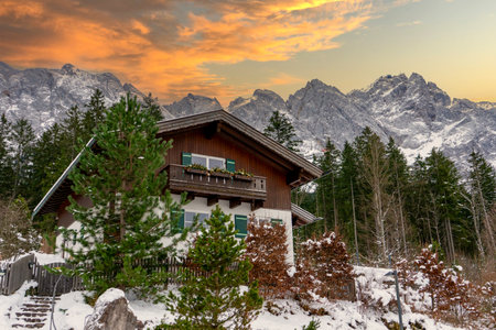 mountain hut in the mountains at the Zugspitze in the Alps with sunsetの写真素材