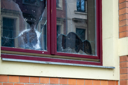 Window of an apartment smashed, vandalism symbols of burglarsの写真素材
