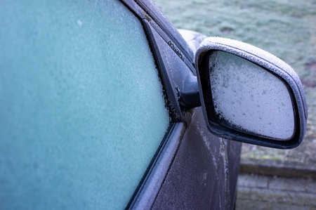 Car mirror in winter in freezing cold with frost in the morningの写真素材