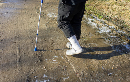 Old man with walking aid in winter on black ice, risk of slippingの写真素材
