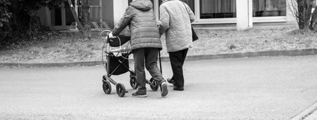Panorama Two old women on a street with a walker and a walking stick black and white photographyの写真素材