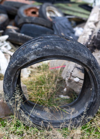 old tire at a recycling center with other scrap verticalの写真素材