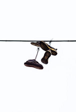 old shoes hanging on a rope verticallyの写真素材