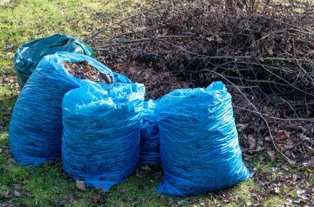 Blue garbage bags with garden waste in spring for recyclingの写真素材