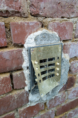 Vandalism of a doorbell on an apartment building verticallyの写真素材