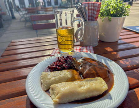 Saxon sauerbraten with wrapped dumplings and red cabbage in a beer garden in spring in the sunshineの写真素材
