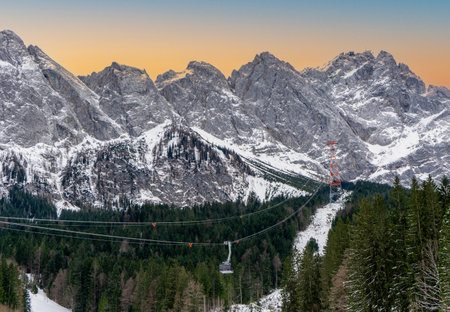 Zugspitz cable car at the Zugspitze in the German Alps in winter with snow and blue sky at sunsetの写真素材