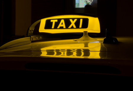 Taxi sign on the street in Germany at nightの写真素材