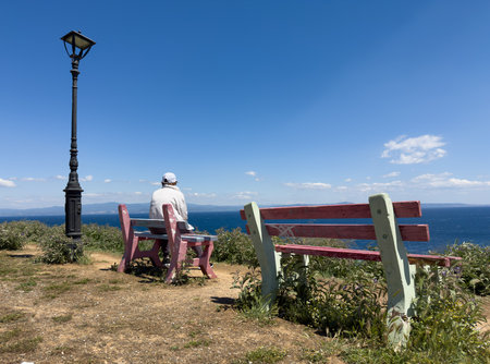 woman on the wooden bench on beach in Afytos is a village in Chalkidiki island, northern Greece.の写真素材