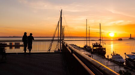 Romantic couple meets the dawn in the seaportの写真素材