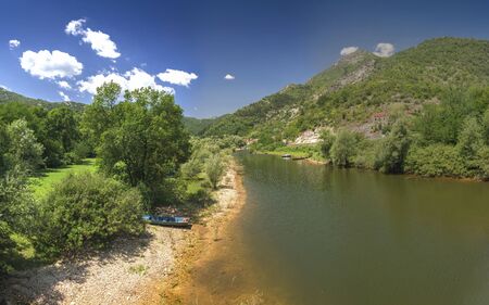 Skadar lake, Montenegro - 07.15.2018.  Panoramic view of the Old Bridge over Crnojevica river, Rijeka Crnojevica, and the tourist area near the bridge, Rijeka Crnojevica.のeditorial素材