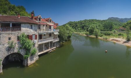 Skadar lake, Montenegro - 07.15.2018.  Panoramic view of the Old Bridge over Crnojevica river, Rijeka Crnojevica, and the tourist area near the bridge, Rijeka Crnojevica.のeditorial素材