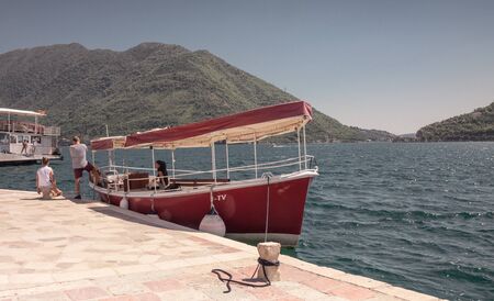 Perast, Montenegro - 07.11.2018.  Tourists on the pier of the island near the old church in the Bay...