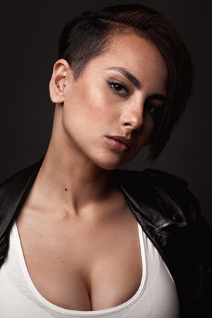 Beauty sexy woman in a leather jacket. Portrait on a dark backgroundの写真素材