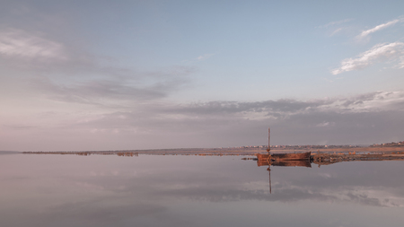 Panoramic view of the lake and the old boat at sunset of a summer dayの写真素材