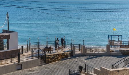 Odessa, Ukraine - 12.27.2018. Lonely people on the pier by the sea on a sunny winter dayのeditorial素材