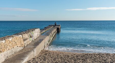 Odessa, Ukraine - 12.27.2018. Lonely people on the pier by the sea on a sunny winter dayのeditorial素材